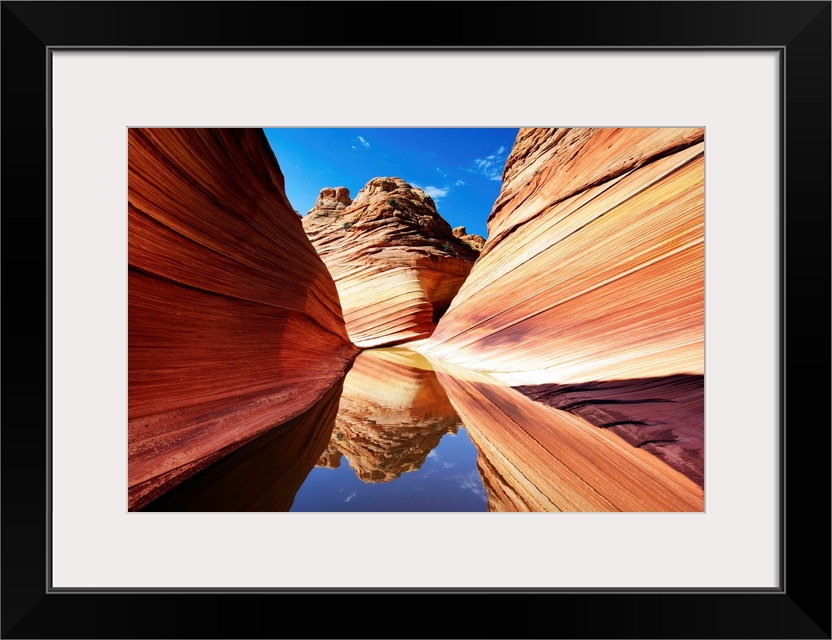 Photograph of a desert landscape with a pool of still water reflecting everything around.