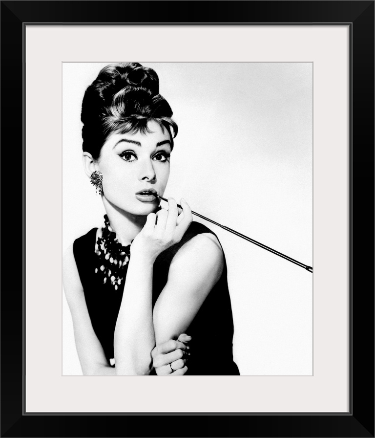 This wall art is a portrait photograph of the Hollywood Icon character Holly Golightly in her signature black dress, jewel...