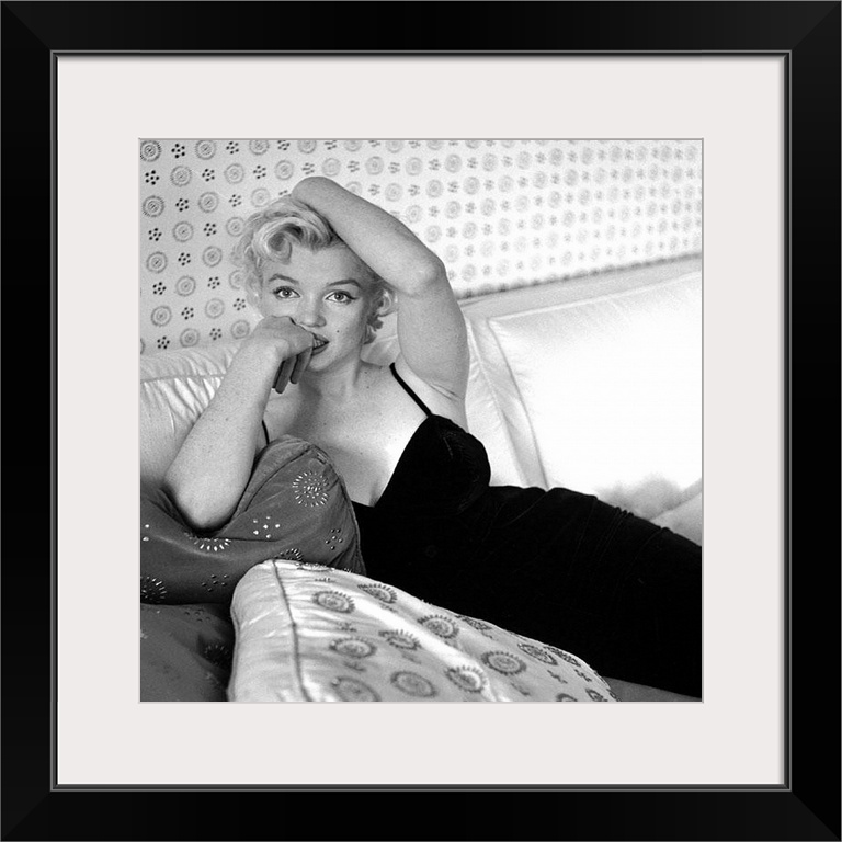 Wall art of Marilyn Monroe sitting on a sofa looking at the camera.