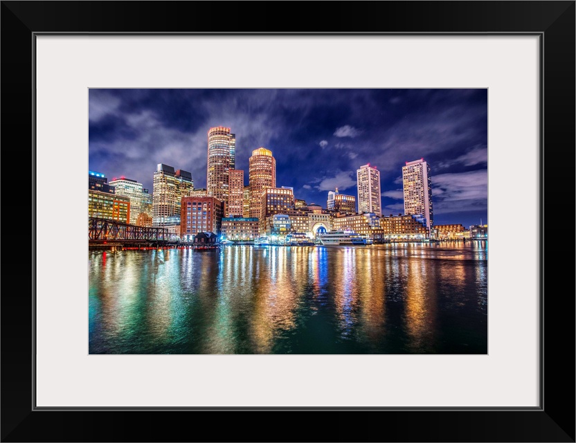 The lights of downtown Boston reflect upon Massachusetts Bay.