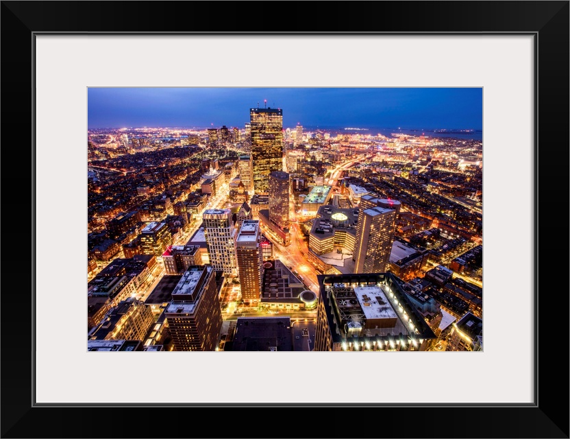 Aerial view of the city of Boston, Massachusetts, lit up at night.