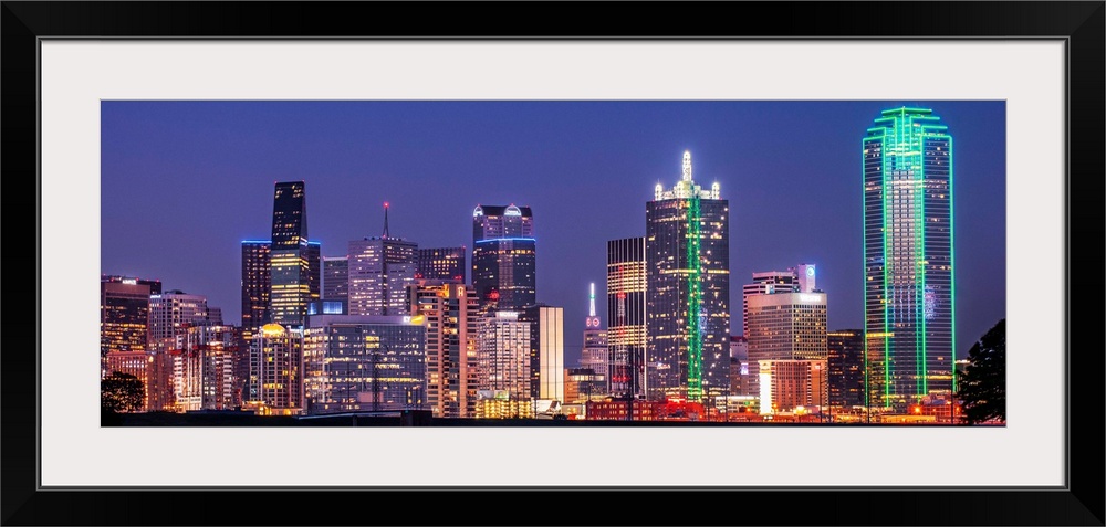 A horizontal image of the Texas city skyline at night.