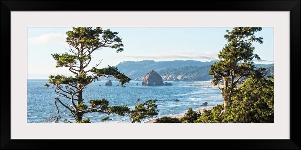 Landscape photograph of Cannon Beach through the trees with Haystack Rock in the distance, Oregon Coast