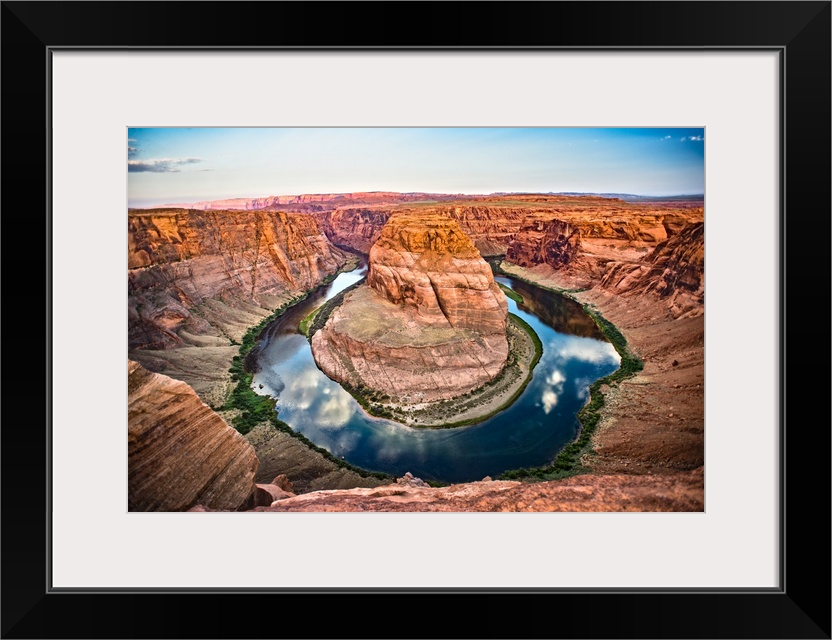 Landscape photograph of Horseshoe Bend in Page, Arizona with blue cloudy skies reflecting into the Colorado River and cont...