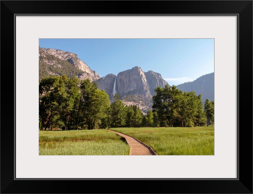 View of wooden pathway with Yosemite Falls in the background, Yosemite National Park, California.