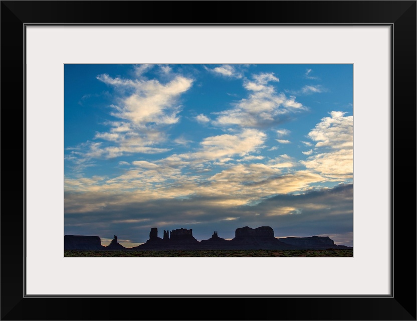 Silhouette of Sentinel Mesa, Big Indian, Stagecoach and Brighams Tomb rock formations, Monument Valley, Utah.