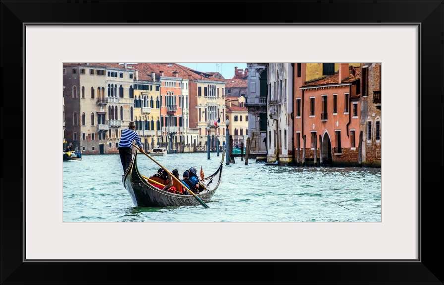 Photograph of the rear side of a gondola rowing through Grand Canal in Venice.