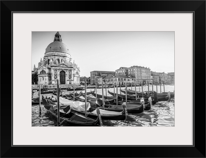 Photograph of gondolas lined up in a row in front of Santa Maria della Salute, Venice, Italy, Europe.