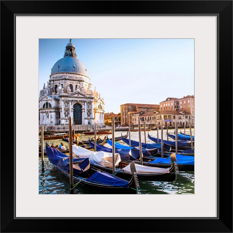 Square photograph of gondolas lined up in a row in front of Santa Maria della Salute, Venice, Italy, Europe