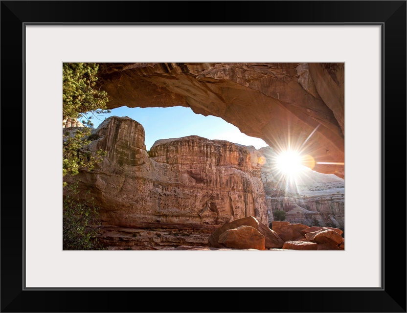 The sun peeking through Hickman Bridge arch at Capitol Reef National Park in Utah.