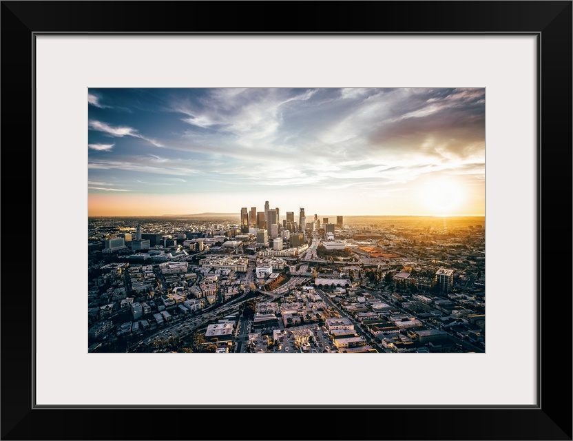 The setting sun visible behind the skyscrapers in the Los Angeles skyline, California.