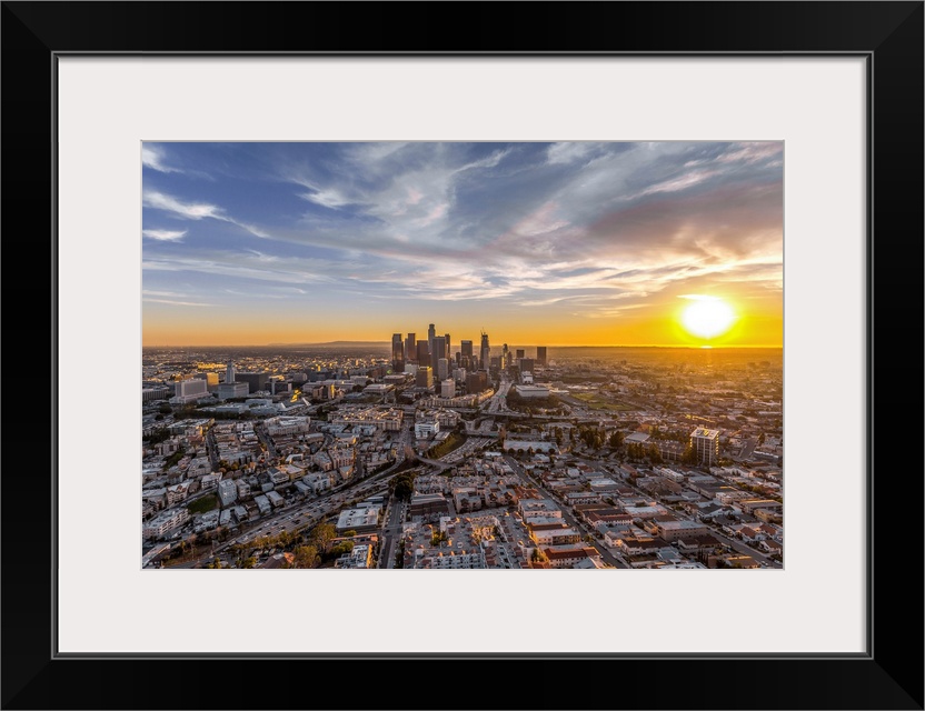 The setting sun visible behind the skyscrapers in the Los Angeles skyline, California.