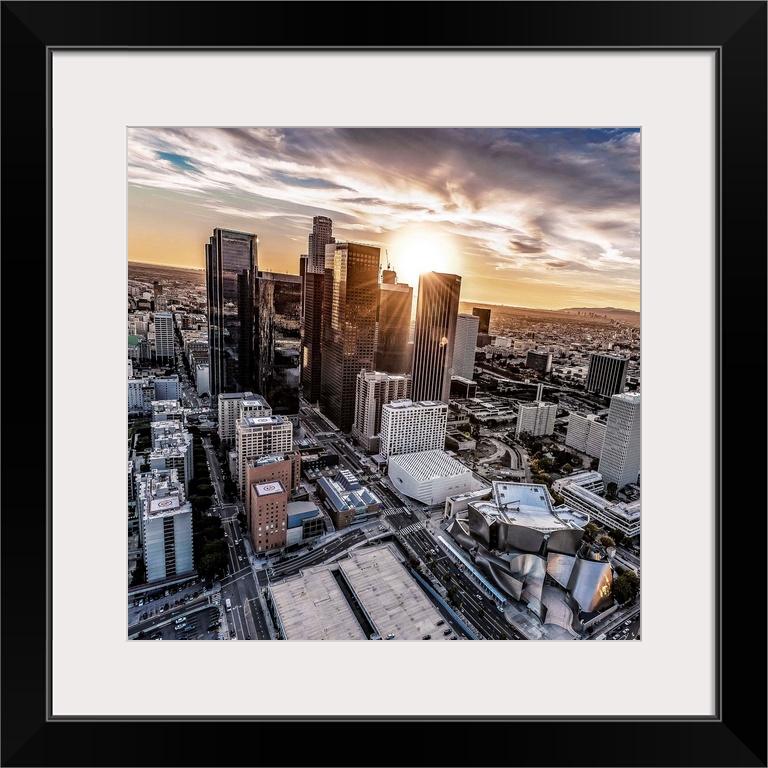 The setting sun visible behind the skyscrapers in the Los Angeles skyline, California.