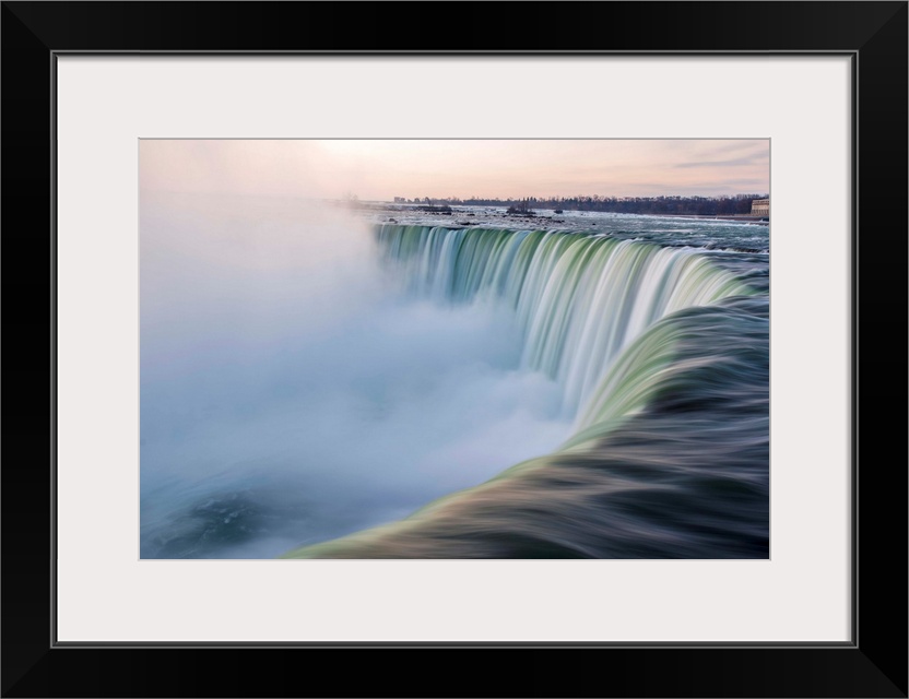 Water cascades down at Horseshoe Falls while dramatic mist ascents to meet the rising sun.