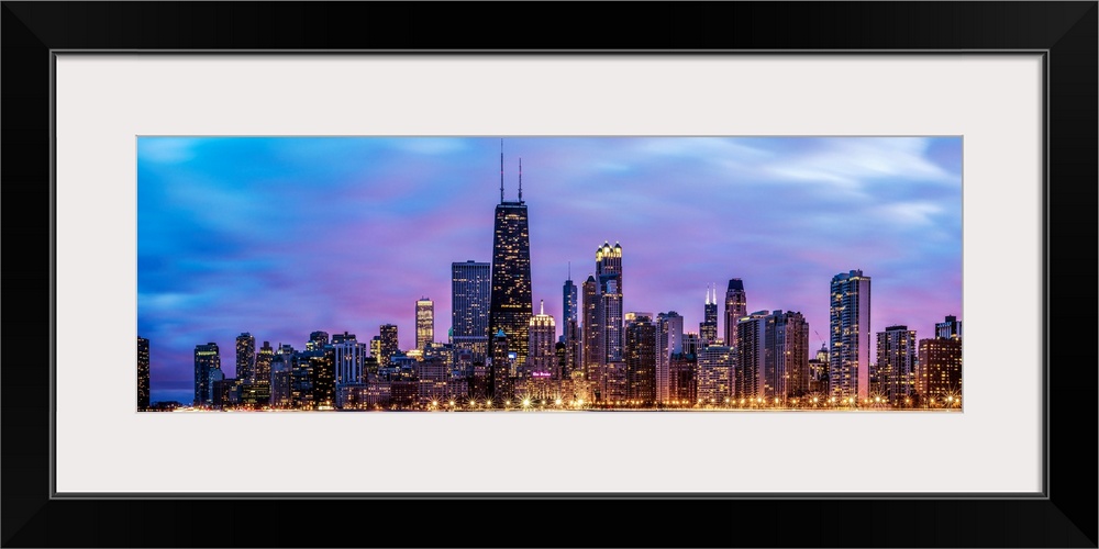 Photo of Chicago skyline at night under cotton candy colored clouds.