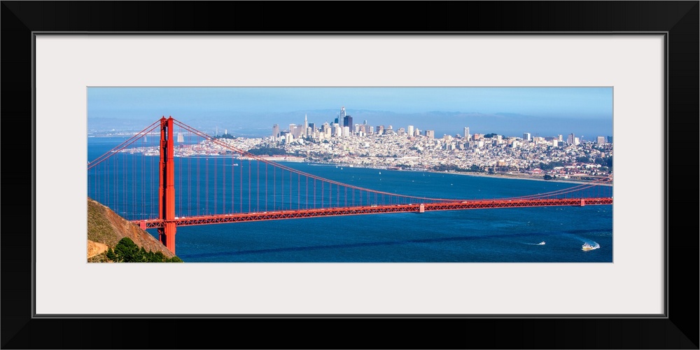 Panoramic photograph of the Golden Gate Bridge with San Francisco's skyscrapers in the background.