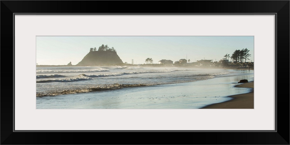 Panoramic landscape photograph of the La Push Beach shore with misty rock cliffs in the background.