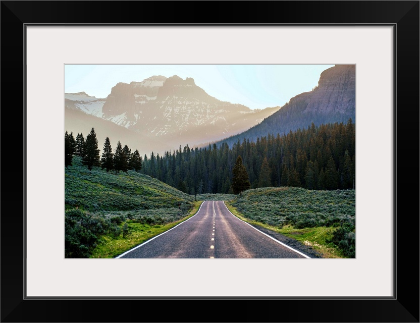 Horizontal image of a road heading to the mountains at Yellowstone National Park.