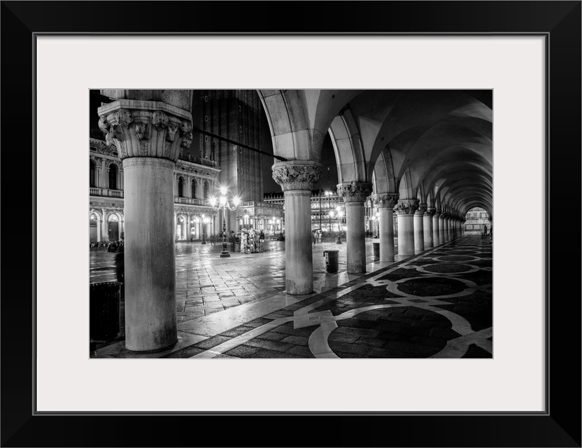 Photograph of the view from underneath arches at night in St. Mark's Square, Venice.