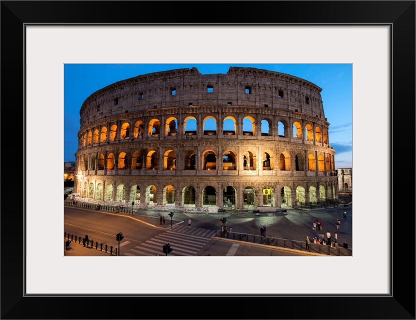 Photograph of the Colosseum lit up at dusk.