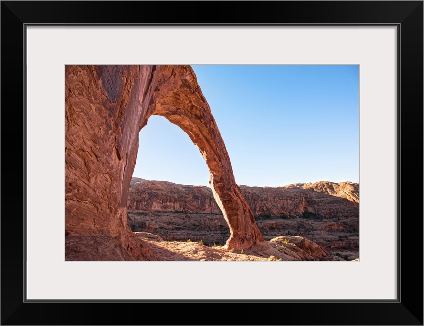 Sunlight shining on the desert landscape around the Corona Arch, Arches National Park, Utah.