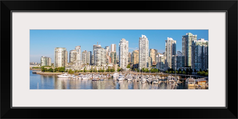 Panoramic photograph of part of the Vancouver, British Columbia skyline with False Creek Harbor and boats in the foreground.