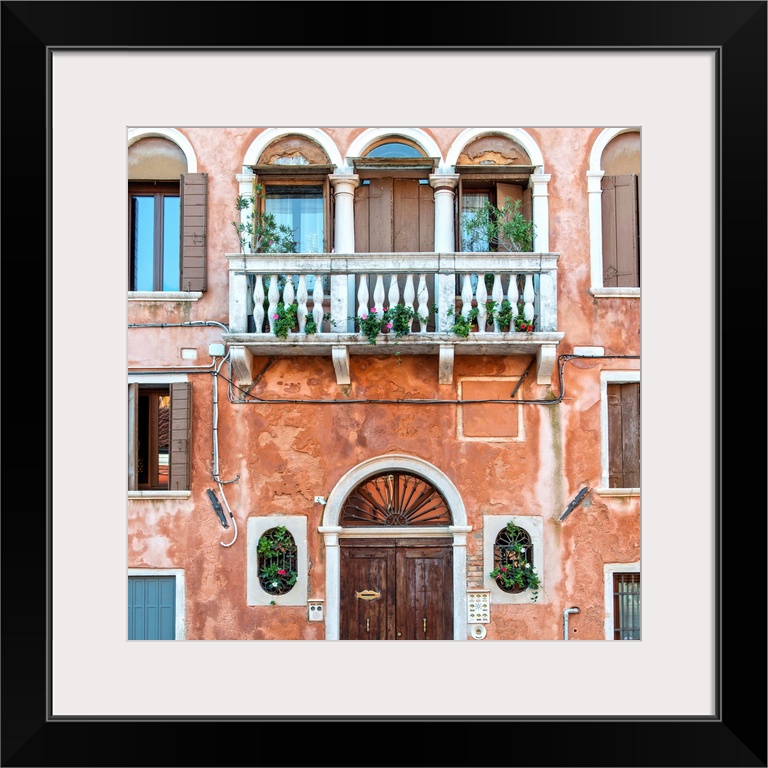 Square photograph of an Italian facade in Venice with a door, windows, and a balcony.