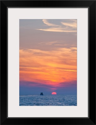 Boat driving into the sunset at Zlatni Rat Beach, Bol, Brac Island, Adriatic, Croatia