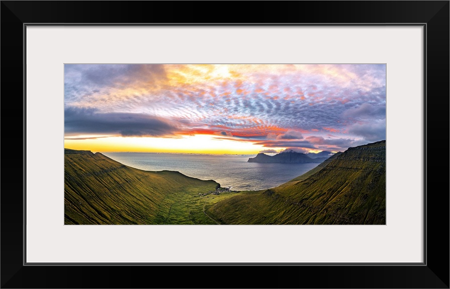 Dramatic sky with clouds at sunrise over the coastal village of Gjogv, aerial view, Eysturoy Island, Faroe Islands, Denmar...