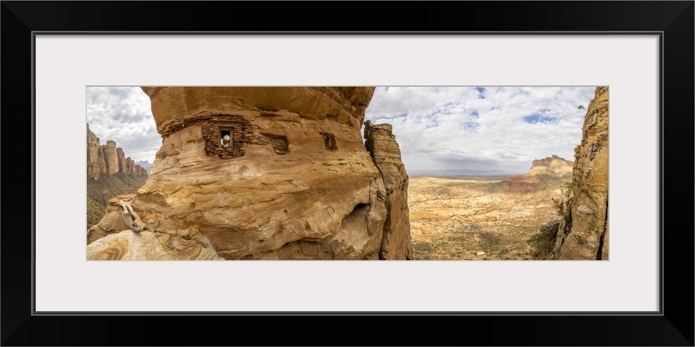 Aerial panoramic by drone of priest looking out from Abuna Yemata Guh rock-hewn church, Gheralta Mountains, Tigray region,...