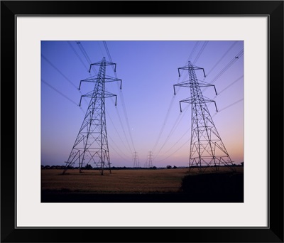 Pylons in a rural landscape at dusk