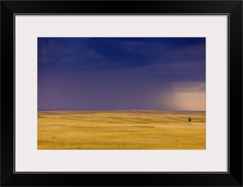 Rolling plains against a dark stormy sky in the Badlands, South Dakota, United States of America, North America