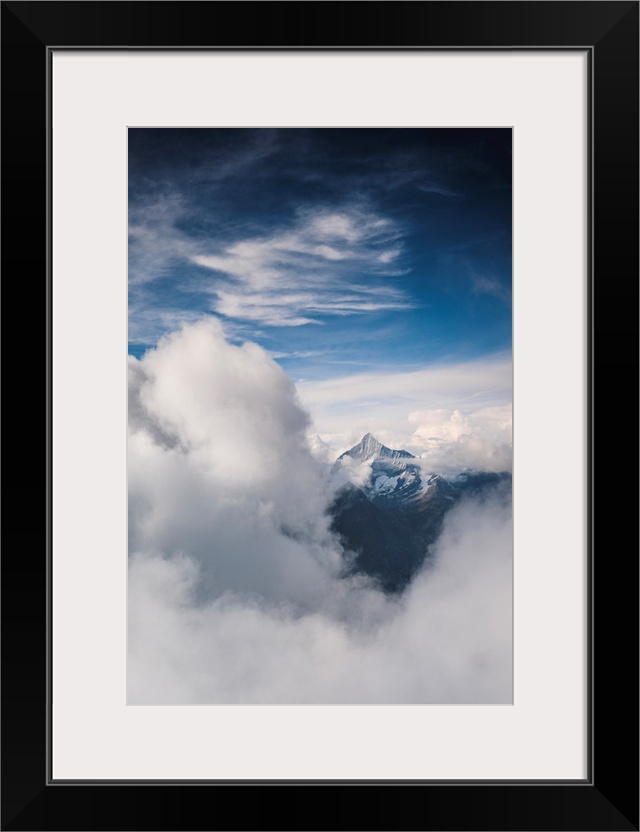 Sunlight over Weisshorn peak emerging from a sea of clouds, canton of Valais, Switzerland, Europe