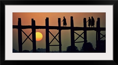 Monks walking across the Ubein Bridge in Burma at sunset