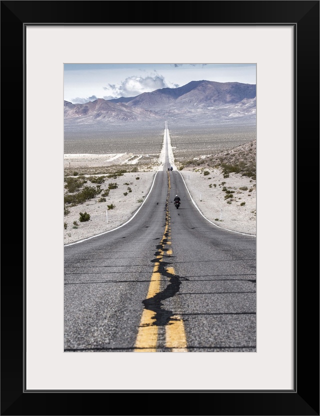 Motorcycles riding long road into Death Valley National Park