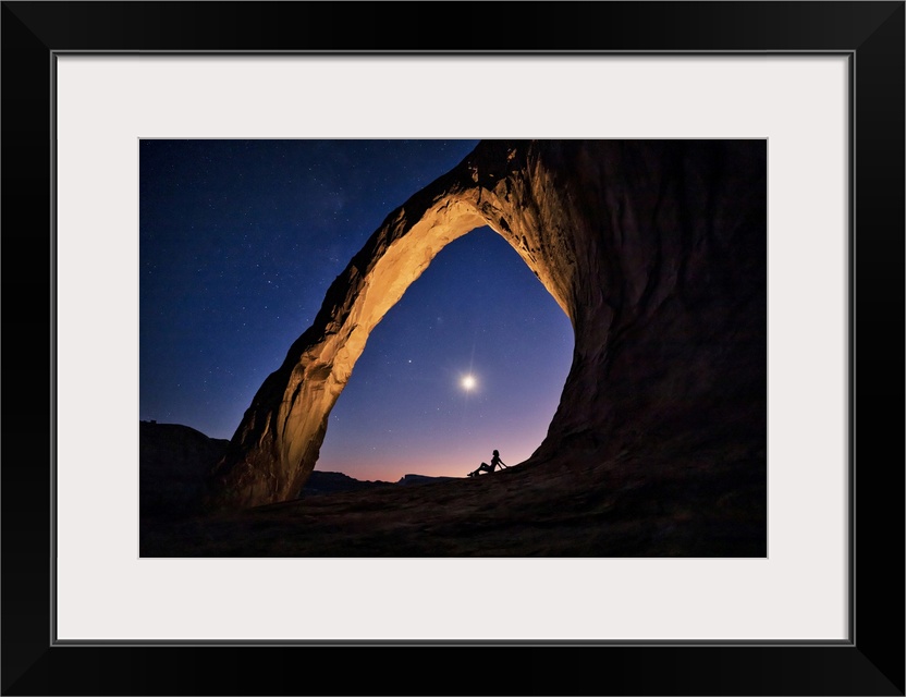 Silhouette of a woman under Corona Arch in Moab, Utah