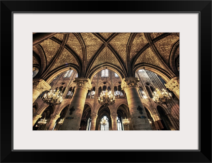 This photograph is taken inside of the Notre Dame Cathedral looking up at the beautiful arch ceiling.