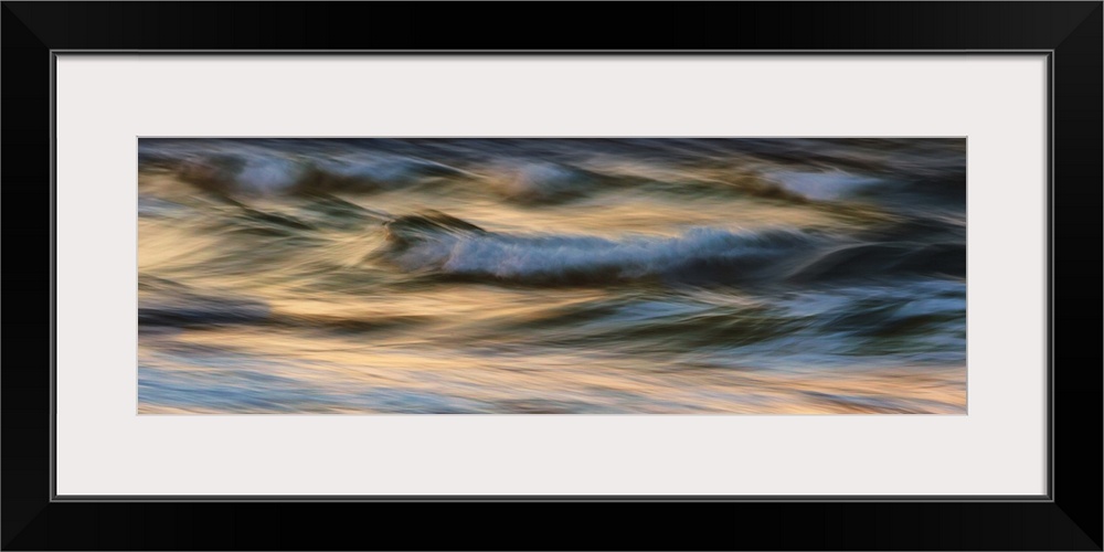 Waves crashing on the beach at sunset in Greece