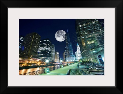 Dramatic view of Chicago at night, with large moon in the sky