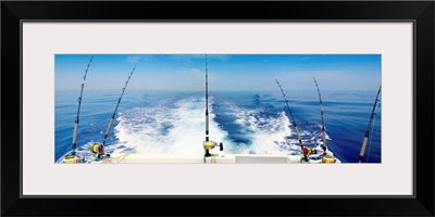 Fishing reels with cast lines off the back of a boat