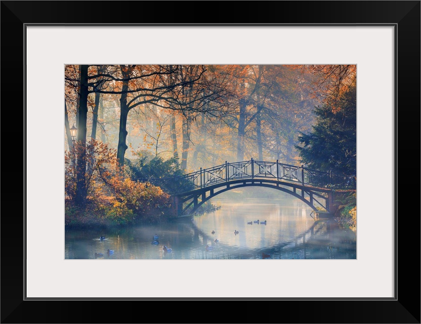 Old bridge in misty park at autumn.
