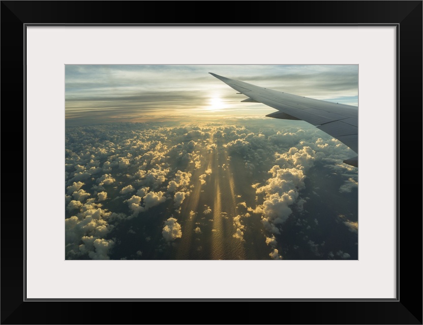 View From Airplane Side Window Of Sunset Sky And Sunlit Clouds