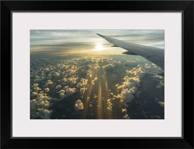 View From Airplane Side Window Of Sunset Sky And Sunlit Clouds