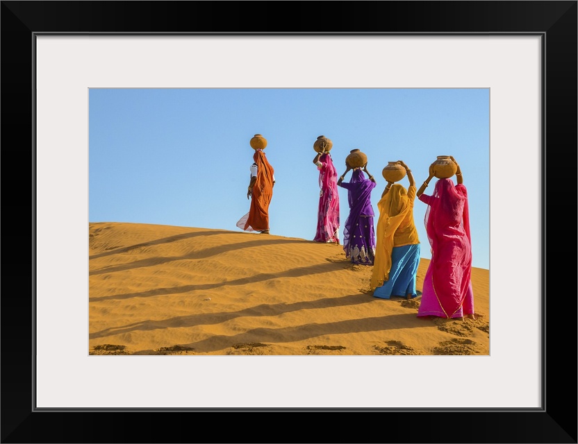 Women Carrying Jugs Of Water In The Hot Summer Desert