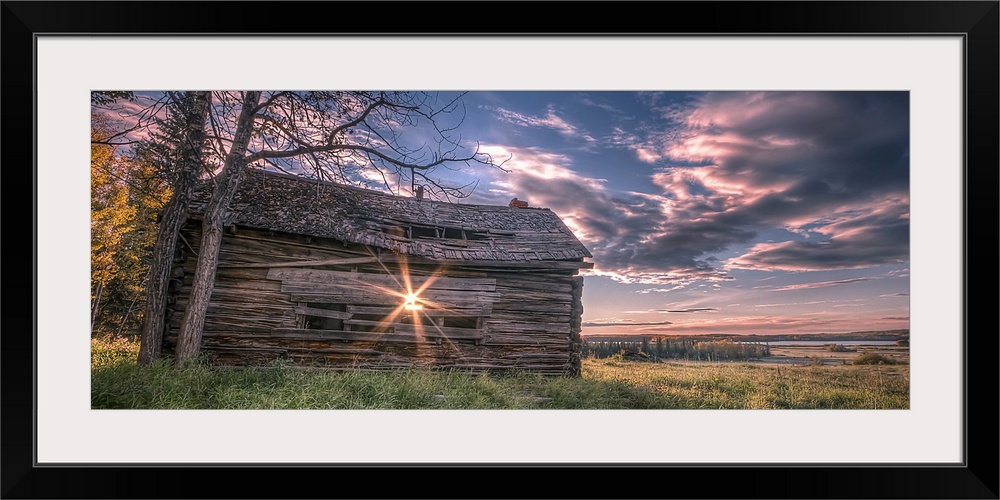 Sunrise beaming through the slats of an old Canadian prairie barn overlooking a field.