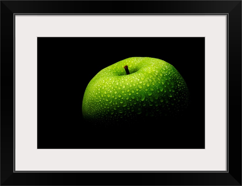 A close up photograph of a fresh Granny Smith apple with waterdrops.