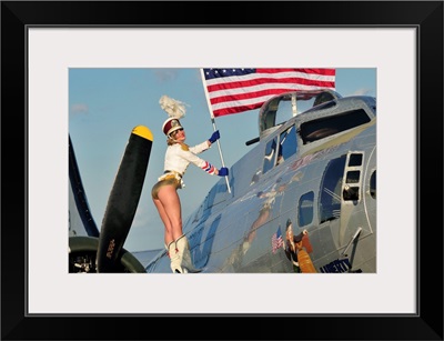 1940's style majorette pin-up girl on a B-17 bomber with an American flag