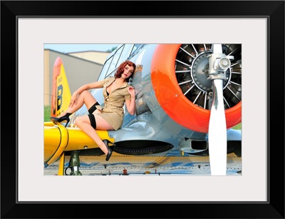 1940's style pin-up girl posing on a T-6 Texan training aircraft