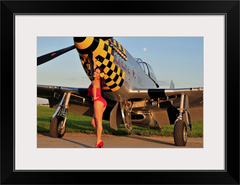 Sexy 1940's style pin-up girl posing with a P-51 Mustang fighter plane.