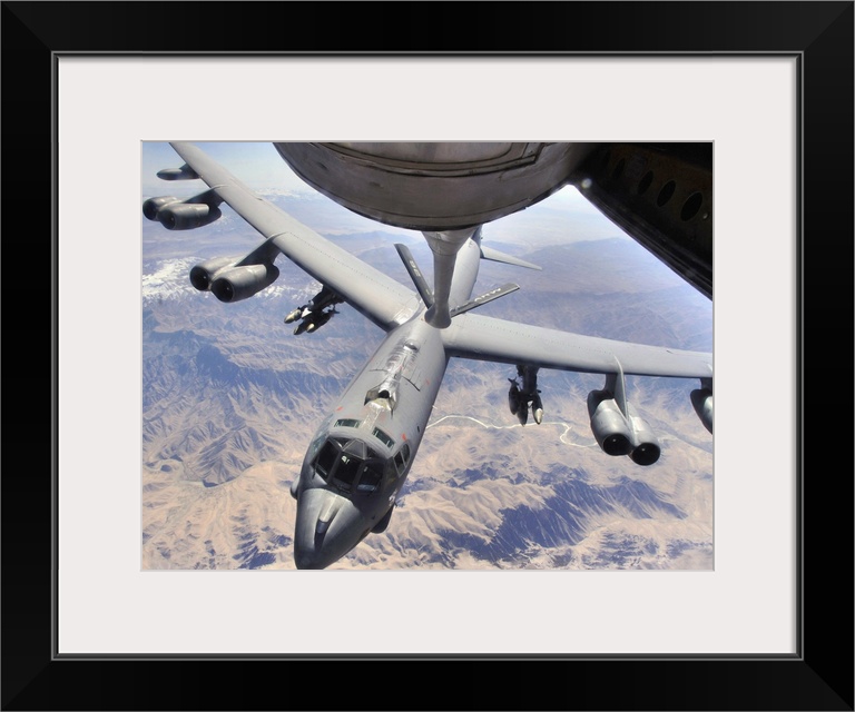This horizontal photograph has been taken from the underside of an aerial refueling aircraft during refueling a long-range...